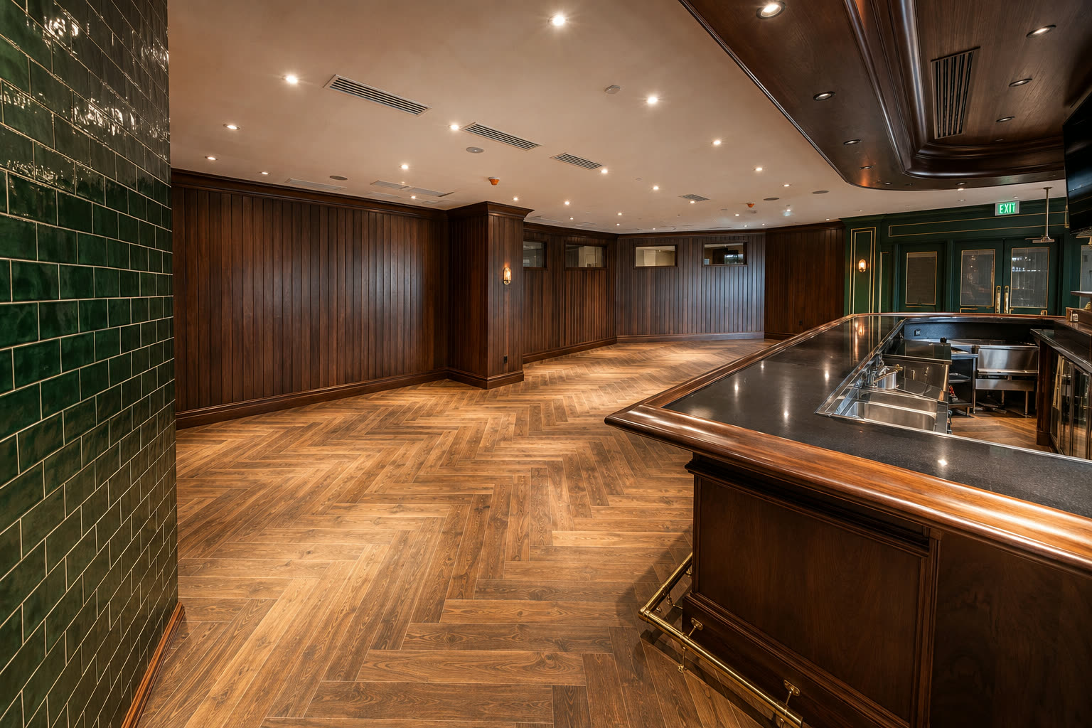 Glossy green subway tile wall behind a bar with herringbone wood-look floor